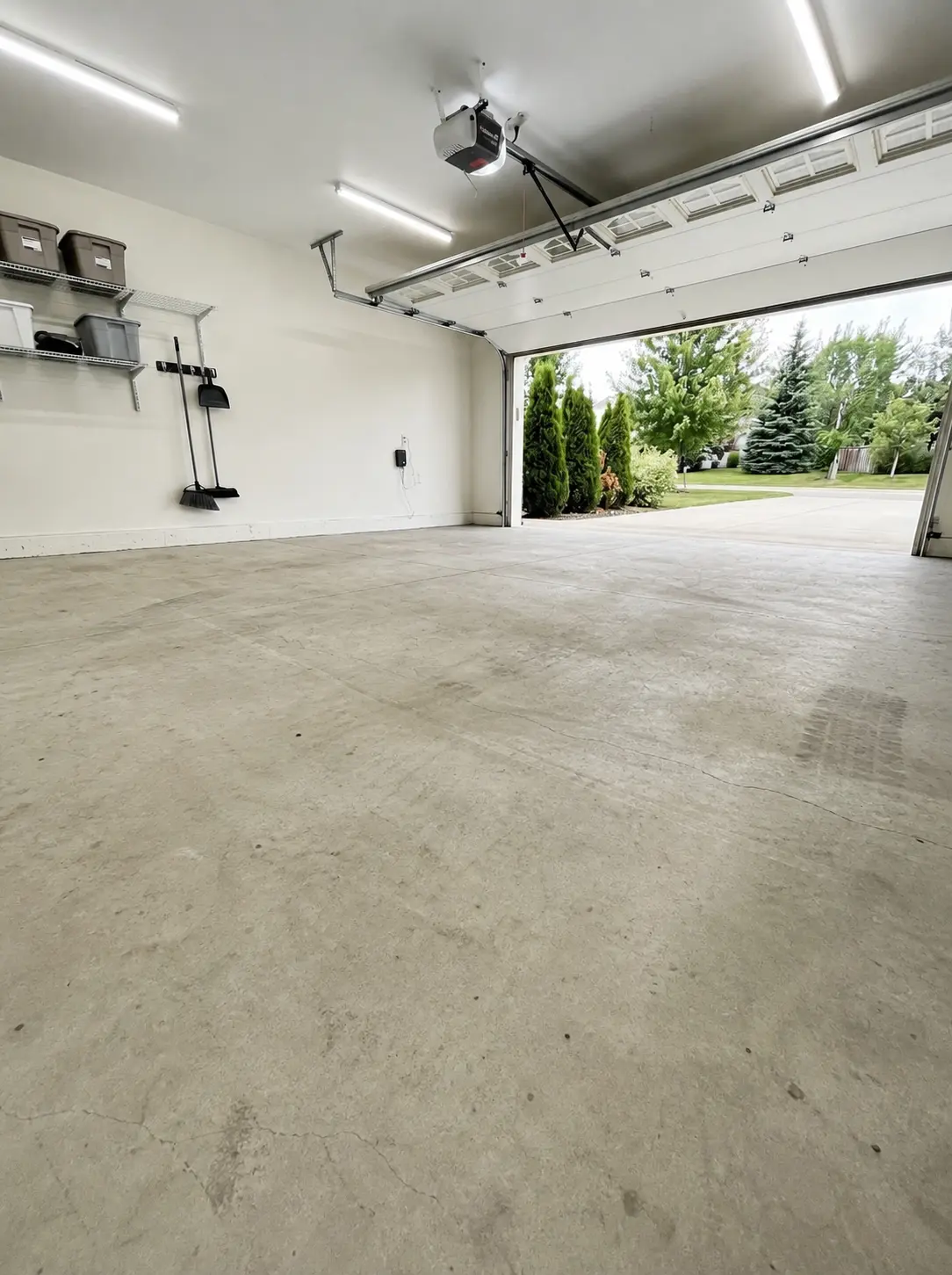 Two-car garage with a plain grey concrete floor before coating
